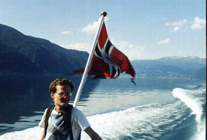 Our speed boat to Flåm marks its passage. The flag of Norway whips about
       just behind me.
